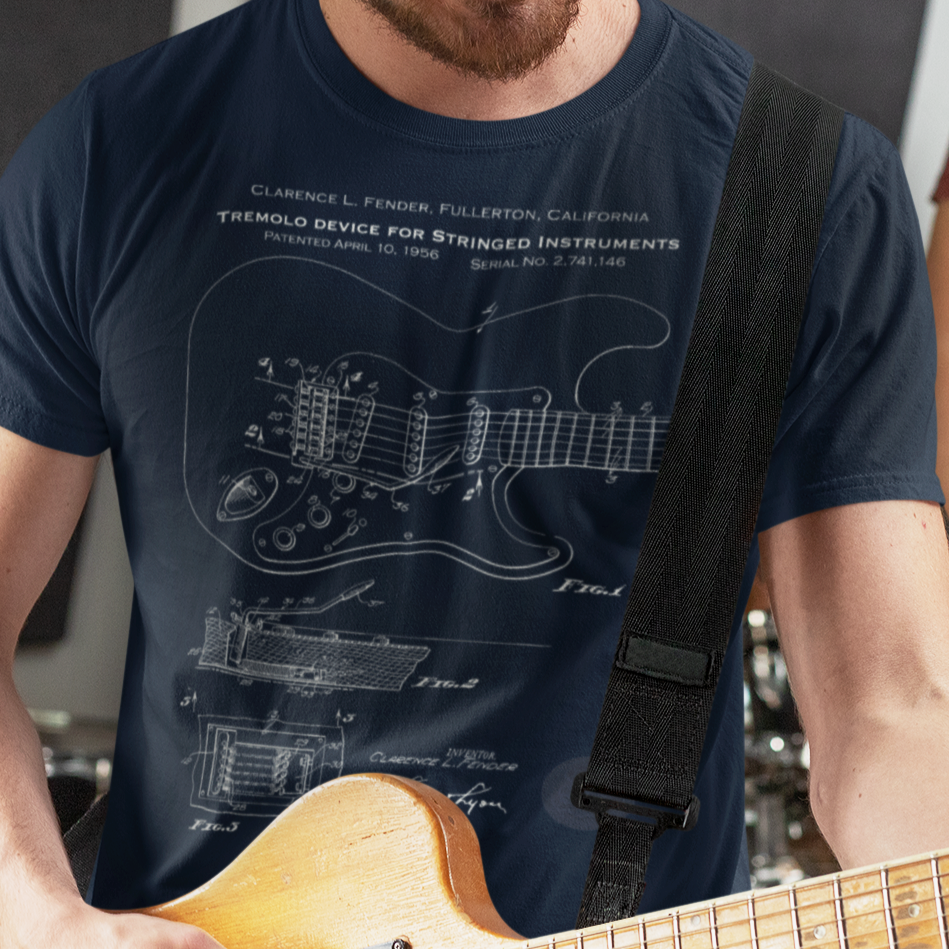 Person wearing a navy blue t-shirt with a guitar design and holding a guitar
