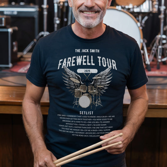 Man wearing a 'Farewell Tour' t-shirt holding drumsticks in front of a drum set.
