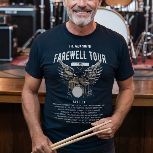 Man wearing a 'Farewell Tour' t-shirt holding drumsticks in front of a drum set.