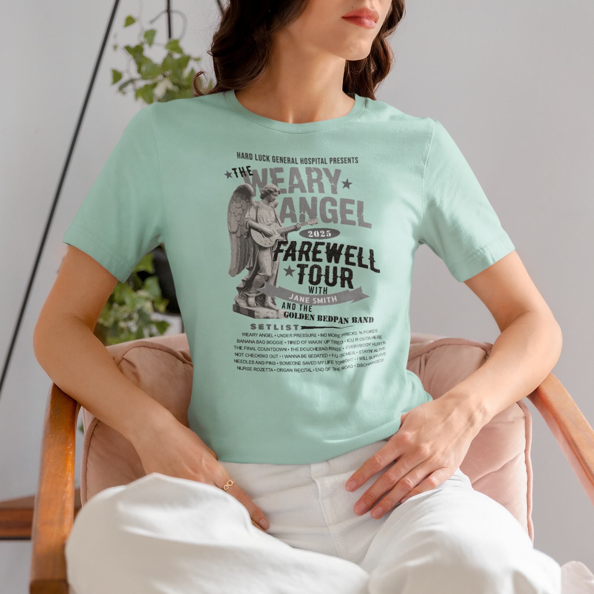 Person wearing a light blue t-shirt with graphic design sitting on a chair.