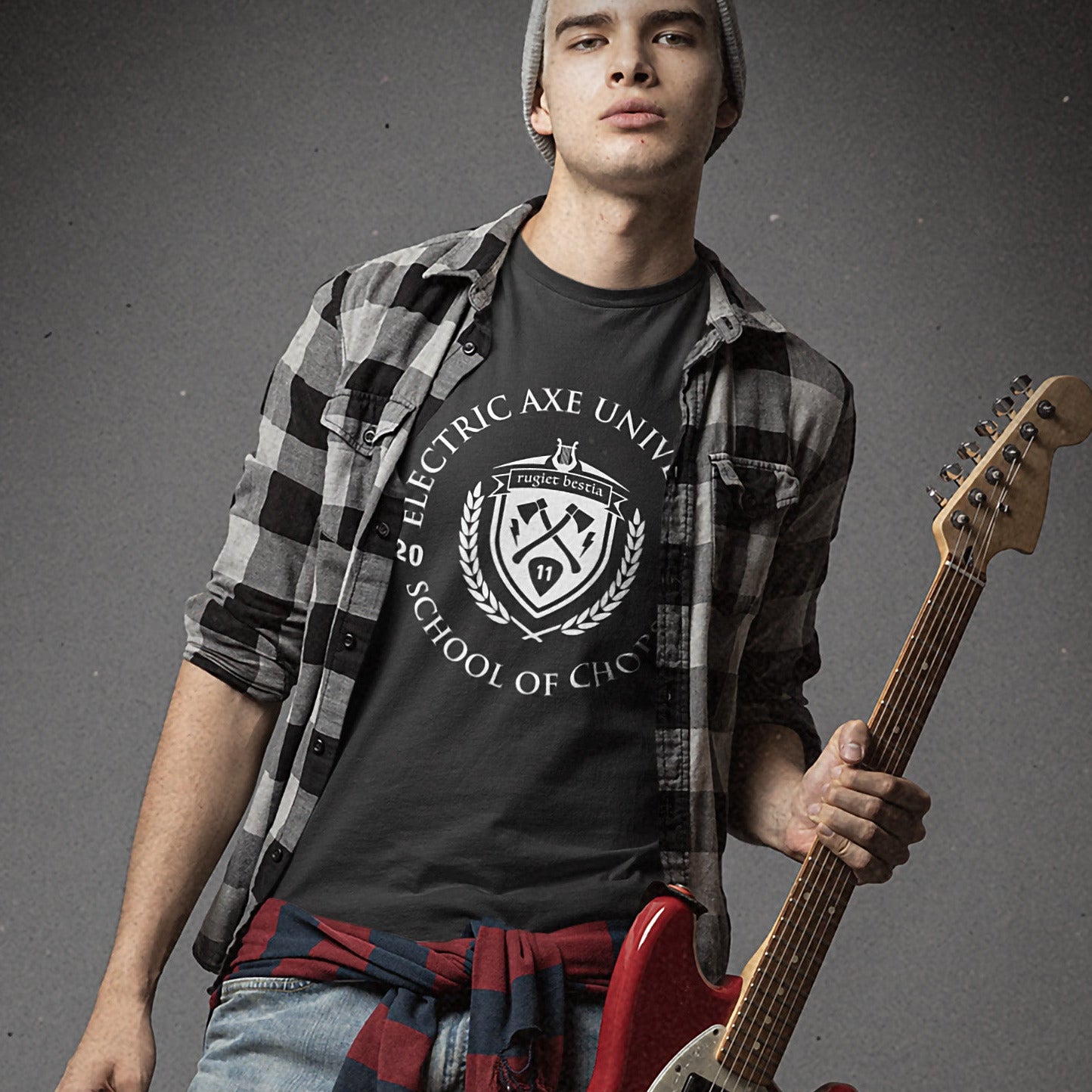 Person holding a red electric guitar against a gray background