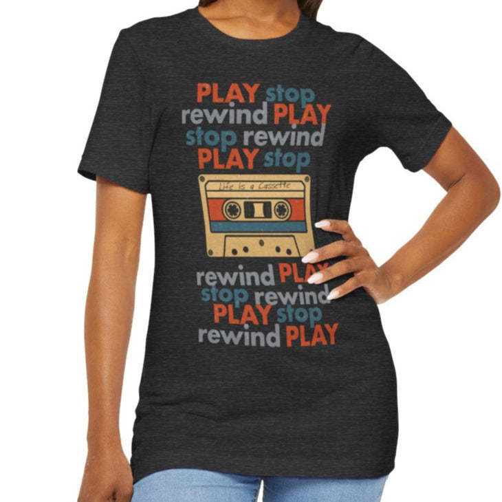 Woman wearing a black t-shirt with colorful text and a cassette tape graphic on a white background